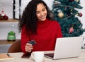 The way you spend Christmas is far more important than how much. Shot of a young woman shopping online at home. Royalty Free Stock Photo