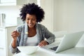 Fueling up for a great day. Shot of a young woman surfing the net while enjoying breakfast in her kitchen at home. Royalty Free Stock Photo