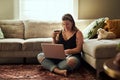 Less queues more relaxing. Shot of a young woman using a laptop and credit card in her living room at home. Royalty Free Stock Photo