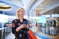 Young woman using mobile phone in shopping mall Royalty Free Stock Photo