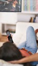 Taking it easy in front of the tv. Shot of a young woman watching television at home. Royalty Free Stock Photo