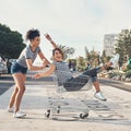 Good friends keep the bad days at bay. Shot of a young woman pushing her friend around on the promenade in a shopping