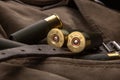 Shotgun shells close-up. Ammunition for smoothbore weapons on a khaki canvas backpack. Dark back Royalty Free Stock Photo