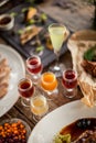 Shots cherry lemon apple cranberry on wooden table at feast with plates restaurant