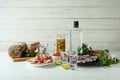Shots of vodka and tasty snacks on white wooden background Royalty Free Stock Photo