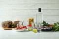 Shots of vodka and tasty snacks on white wooden background Royalty Free Stock Photo