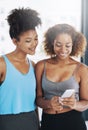 We should meet up outside of yoga. two young women looking at a cellphone after yoga class. Royalty Free Stock Photo