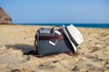 Shoulder bag with a smartphone and a white hat on the sand of the beach Royalty Free Stock Photo