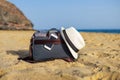 Shoulder bag with a smartphone and a white hat on the sand of the beach Royalty Free Stock Photo