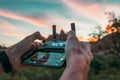 Shoulder hand piloting drone at sunset