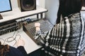 Shoulder view of a girl working with studio equipment on a white table near white walls Royalty Free Stock Photo