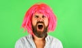 Shouting bearded man in pink wig. Angry man with beard and mustache in colored wig. Screaming guy with pink hair Royalty Free Stock Photo