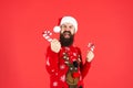 shouting bearded man in santa claus hat. brutal hipster in winter knitted xmas sweater. Royalty Free Stock Photo