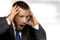 Shouting businessman holding his head in his hands