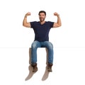 Shouting Happy Handsome Man Is Sitting On A Top And Flexing Muscles Royalty Free Stock Photo