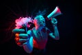Shouting with megaphone. Young woman with smoke and neon light on black background. Highly tensioned, wide angle, fish Royalty Free Stock Photo