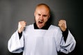 Shouting upset catholic priest in white surplice Royalty Free Stock Photo