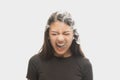 Shouting young girl with dark hair releases smoke from the mouth isolated over white background. Concept of mental