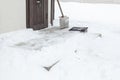 Shovel for clearing snow on snowy steps near the house