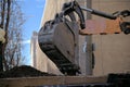 Shovel of an industrial excavator dumps soil onto a pile of dirt