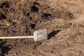 Shovel with a long wooden handle lying on the dug up ground Royalty Free Stock Photo