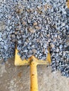 Shovel placed on a pile of stone for construction work. It is used for scooping sand