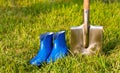 Shovel and rubber boots. Garden tools on a green lawn. Royalty Free Stock Photo