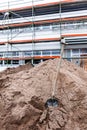 Shovel stuck in the ground at new office and warehouse building construction site Royalty Free Stock Photo