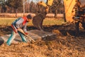 The shovel worker cleans the soil after digging the excavator, laying the road Royalty Free Stock Photo