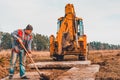 The shovel worker cleans the soil after digging the excavator, laying the road Royalty Free Stock Photo