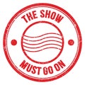THE SHOW MUST GO ON text on red round postal stamp sign