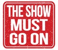THE SHOW MUST GO ON, text written on red stamp sign