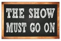 THE SHOW MUST GO ON words on black wooden frame school blackboard