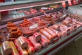 Showcase with boiled and smoked sausage in store. Refrigerator shelves with meat products