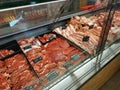 Showcase butcher closeup. A large assortment of meat, minced meat, offal in a butcher`s shop.