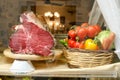 A piece of meat on the stand. Vegetables tomatoes, bell peppers, cabbage, carrots in a basket Royalty Free Stock Photo