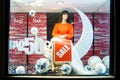 Showcase of fashion store with woman mannequin in dress and sign sale out