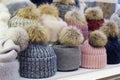Showcase of trade tent with variety of women\'s hats with fur pom-poms