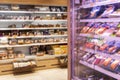 Showcases with products in a supermarket. Assortment of food. Blurred