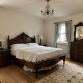 Furnished bedroom within former victorian rectory with ornate carved four poster bed and matching period sideboard drawers, chaise