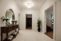 House hallway entrance interior with stairs and furniture. Apartment background with door, mirror, bag on hanger, flower in vase,