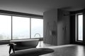 Shower cabin with narrow window in dark grey panoramic bathroom. Corner view