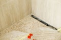 Shower drain in floor and modern mosaic of travertine tile in unfinished bathroom. Construction of house and home renovation Royalty Free Stock Photo