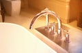 Shower faucet and head on bath tub with blur potty with sun light Royalty Free Stock Photo