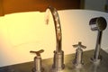 Shower faucet and head on bath tub with blur white towel in bath room atmosphere with sun light Royalty Free Stock Photo