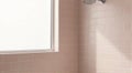 Shower head running water in pink tiled corner with window Royalty Free Stock Photo