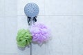 Shower head and two washcloths on tiled wall in the bathroom