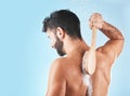 Shower, man and soap for body cleaning with brush in blue background studio, grooming hygiene and skincare wellness Royalty Free Stock Photo