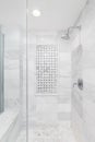 A shower with marble subway and hexagon tiles.