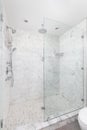 A shower with marble subway tiles and chrome showerhead.